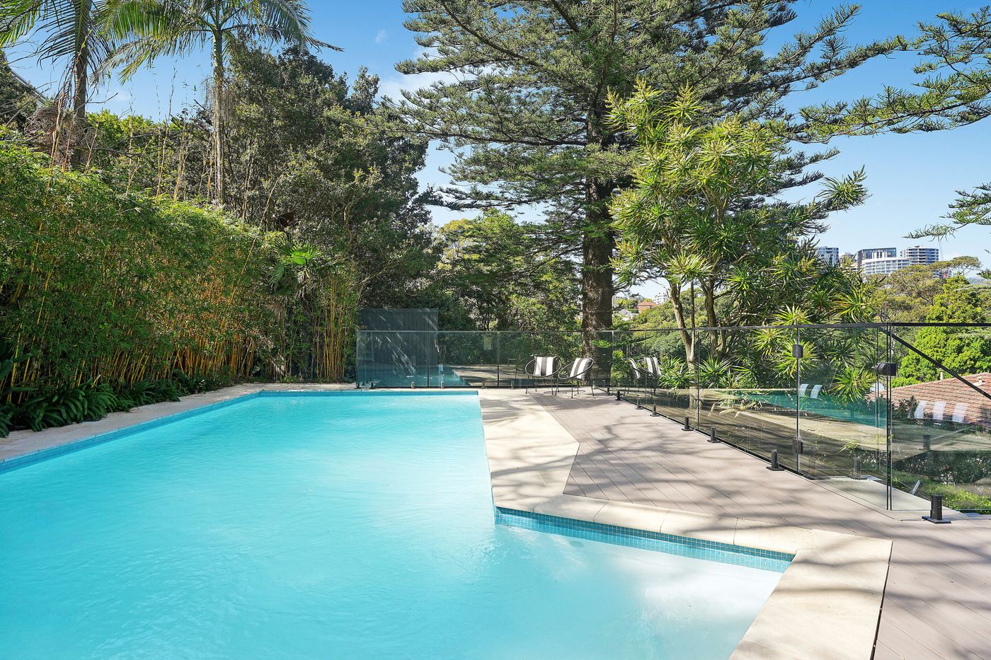 The 10.5-metre solar-heated pool at 32 Northland Road, with the city skyline beyond the trees
